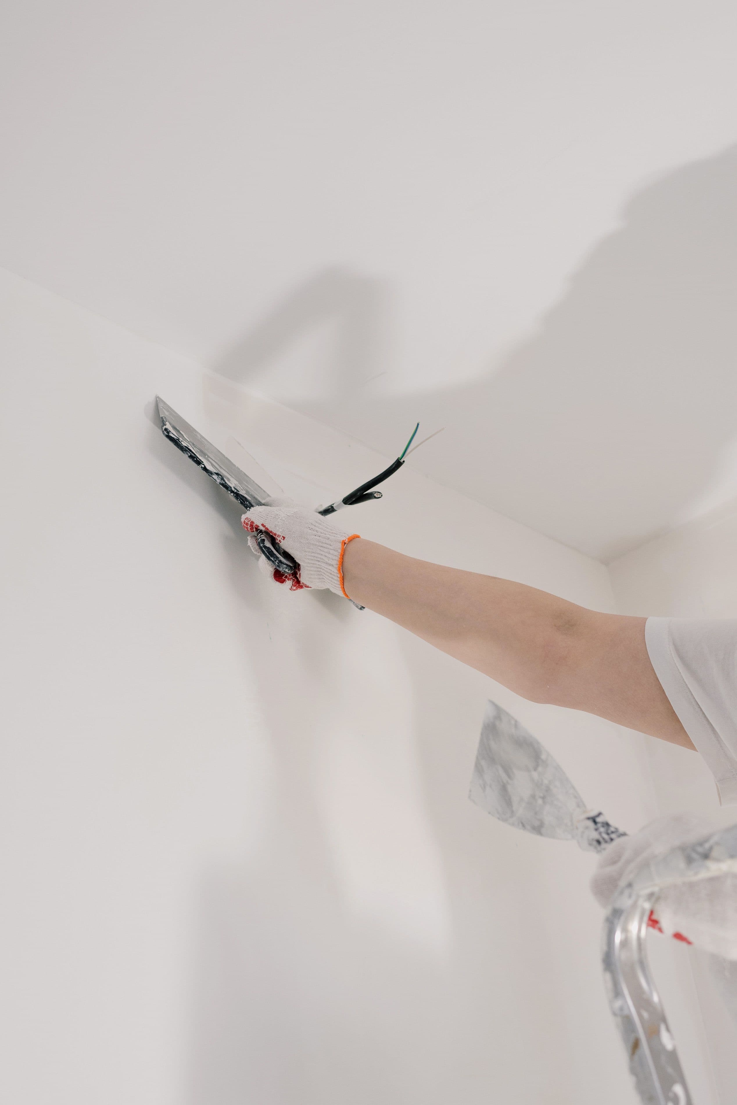 Stukadoor werkt een wand strak af met een spackmes